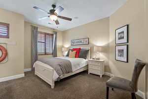 Bedroom featuring dark colored carpet and a ceiling fan