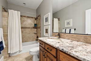 Full bath featuring tile patterned floors, vanity, shower / tub combo with curtain, and tasteful backsplash
