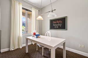 Dining space featuring baseboards and dark colored carpet
