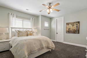Bedroom featuring dark colored carpet and ceiling fan