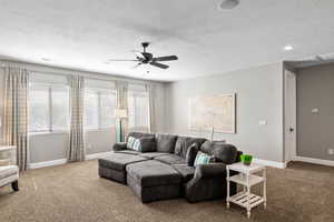 Living area with ceiling fan, carpet flooring, a textured ceiling, and recessed lighting