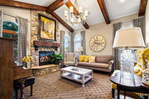 Living room featuring a stone fireplace and a chandelier