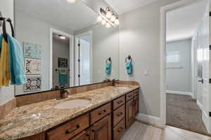 Full bath featuring double vanity and tile patterned flooring