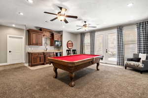 Recreation room featuring recessed lighting, light colored carpet, ceiling fan, billiards, and french doors