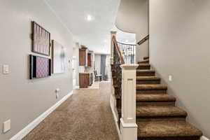 Stairs with carpet flooring and recessed lighting