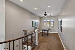 Hallway with an upstairs landing, recessed lighting, and carpet