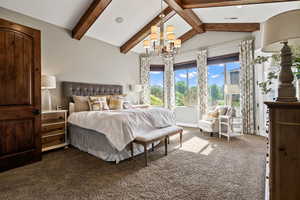 Bedroom with dark carpet and a chandelier