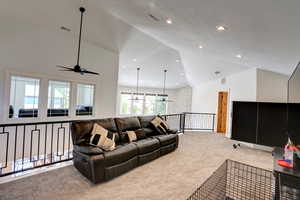 Living room with carpet, ceiling fan, high vaulted ceiling, and recessed lighting