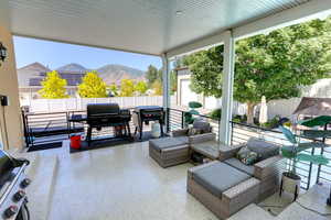 Fenced backyard featuring a mountain view, a patio, and a grill