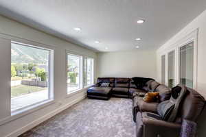 Living room with carpet flooring, recessed lighting, and a textured ceiling