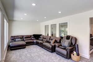 Living area with carpet floors and recessed lighting