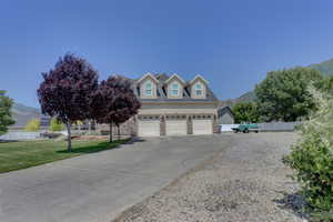 View of front of house with asphalt driveway, an attached garage, and a mountain view