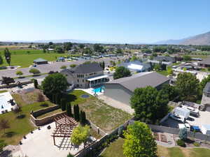 Aerial perspective of suburban area featuring a mountain backdrop and a pool area