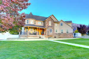 View of front of home featuring covered porch, stone siding, stucco siding, and a mountain view
