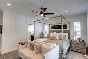 Carpeted bedroom featuring multiple windows, ornamental molding, recessed lighting, a ceiling fan, and connected bathroom