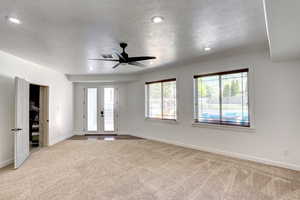 Carpeted spare room with a textured ceiling, ceiling fan, and recessed lighting