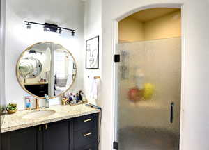Full bath featuring a stall shower and vanity