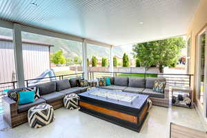 Sunroom / solarium featuring an outdoor living space with a fire pit, a mountain view, and plenty of natural light
