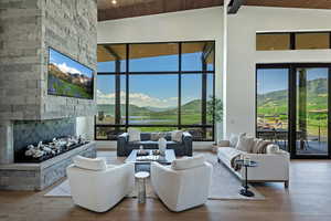 Living room with a wood ceiling with exposed beams, a fireplace, hardwood / wood-style flooring, high vaulted ceiling, and recessed lighting