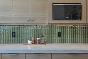 Detailed view of black microwave and stone countertops