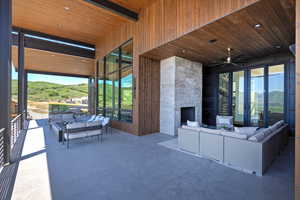 View of patio / terrace featuring an outdoor living space with a fireplace and a ceiling fan