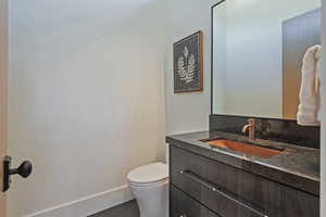 Half bathroom featuring vanity and toilet