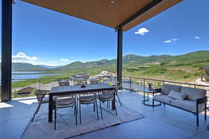 Patio / terrace featuring a water and mountain view and an outdoor living space