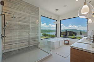 Bathroom featuring a freestanding tub, a shower stall, vanity, recessed lighting, and tile patterned floors