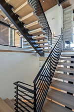 Staircase featuring wood finished floors, a towering ceiling, and wooden ceiling