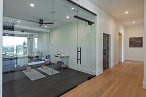 Exercise area with wood finished floors, recessed lighting, and ceiling fan