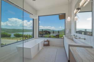 Bathroom featuring a soaking tub, vanity, and a water view