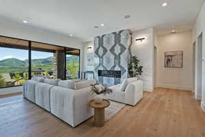 Living area with light wood finished floors, recessed lighting, a mountain view, and a fireplace