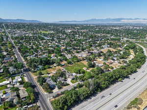 Aerial view of property and surrounding area with mountains and nearby suburban area