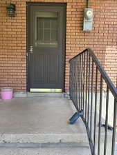 View of exterior entry with brick siding