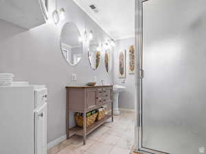 Full bath with crown molding, a stall shower, marble finish flooring, and double vanity