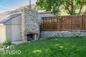 View of yard with an outdoor stone fireplace and a mountain view