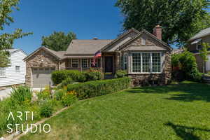 Ranch-style home with stone siding, an attached garage, a chimney, and a front yard