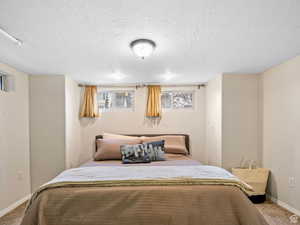 Carpeted bedroom with baseboards and a textured ceiling
