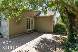 Back of property featuring french doors, a shingled roof, a patio area, and stucco siding