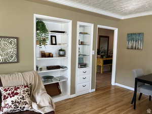 Sitting room with wood finished floors and ornamental molding