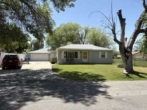 Single story home with a detached garage and roof with shingles