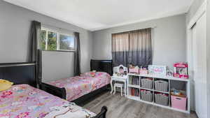 Bedroom with wood finished floors and a textured ceiling