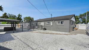 Rear view of property with a gate, a patio area, and brick siding