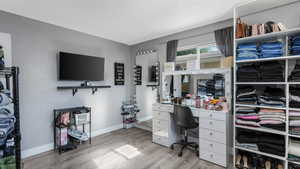 Bedroom with light wood finished floors, a textured ceiling, and an office area