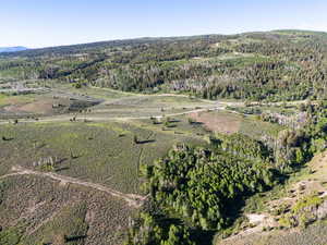 Aerial view of property's location featuring a heavily wooded area and rural landscape