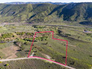 Aerial view of property's location with a mountain backdrop and property boundaries highlighted