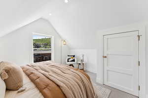 Bedroom with light carpet, lofted ceiling, and recessed lighting