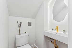 Half bath featuring lofted ceiling