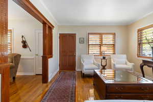 Foyer featuring light wood-style flooring and ornamental molding