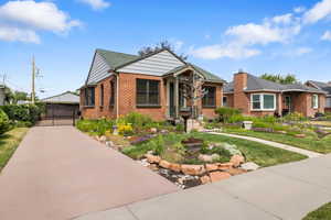 View of front of home with a gate, brick siding, and a front lawn